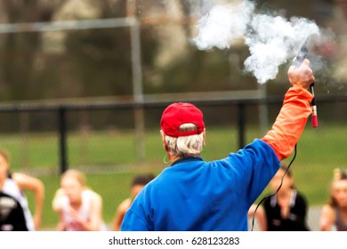 Smoke Rises From The Starters Gun At The Start Of The 1500m Race At A Track Competition