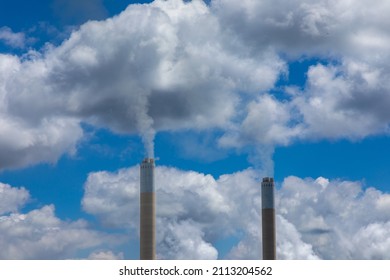 Smoke Rising From Two Smoke Stacks Into The Atmosphere. 
Concept For Greenhouse Gasses Creating Global Warming 