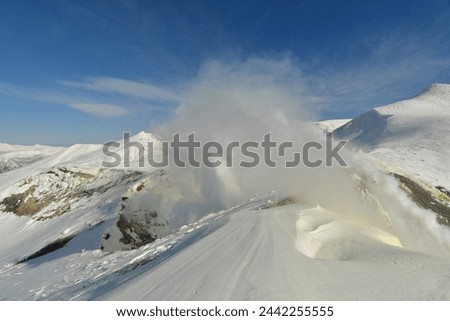 Smoke rising from winter landscape snow-capped Mt. Tokachi volcano, Hokkaido, Japan. High quality photo