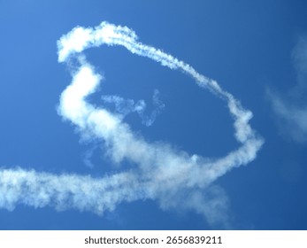 Smoke trails loop through the sky during an airshow aerobatic performance.