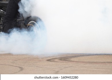 Smoke from under the rear wheel of a motorcycle with the drift. Moto drift
