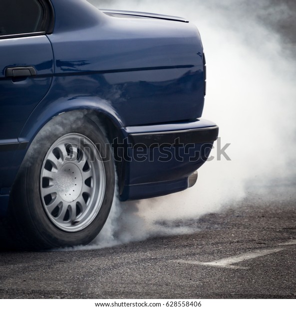 Smoke from under the\
wheels of the car .