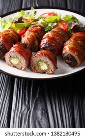 Smoked Armadillo Eggs With Jalapeno And Cheese Wrapped In Bacon Served With Fresh Salad Close-up On A Plate On The Table. Vertical
