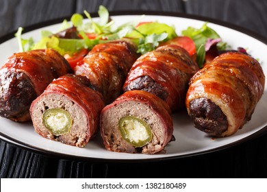 Smoked Armadillo Eggs Wrapped In Bacon Served With Fresh Salad Close-up On A Plate On The Table. Horizontal
