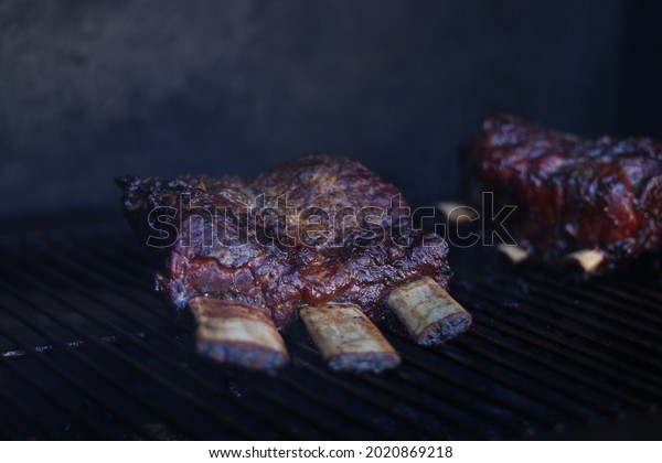 Smoked Beef Short Ribs on a grill or smoker basted and\
cooked 