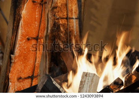 Smoked Fish And Fire Flame. Traditional Food On The Christmas Market In Germany.