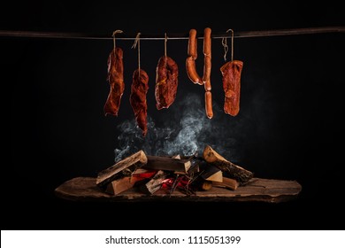 Smoked ham, bacon, pork neck and sausages in a smokehouse.