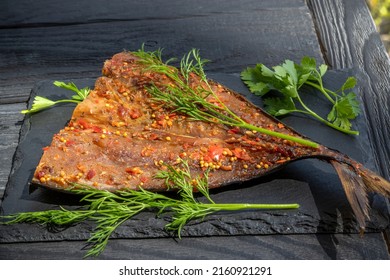 Smoked Mackerel Fillet With Seasoning. On Black Slate Plate. Ready-made Appetizer Of Sea Fish Cooked With Bell Pepper And Spices. On Black Slate Board With Natural Edge .