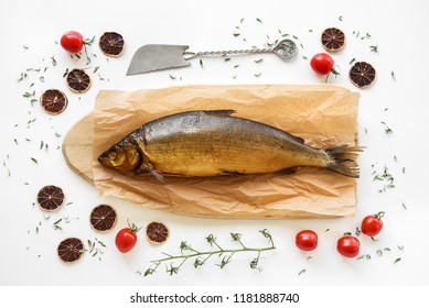 Smoked Omul fish decorated with herbs, baby tomatoes and dried lemon slices.