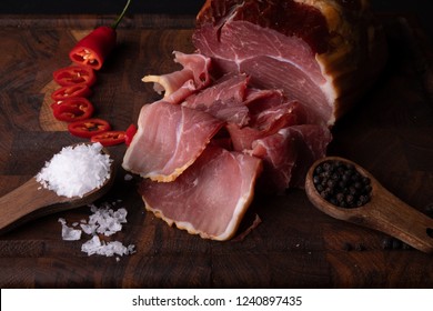 Smoked pork with accompanying spices on a cutting board - Shutterstock ID 1240897435