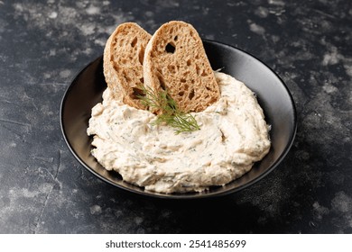 smoked salmon and soft cream cheese pate or mousse in black bowl served with baguette toasts - Powered by Shutterstock