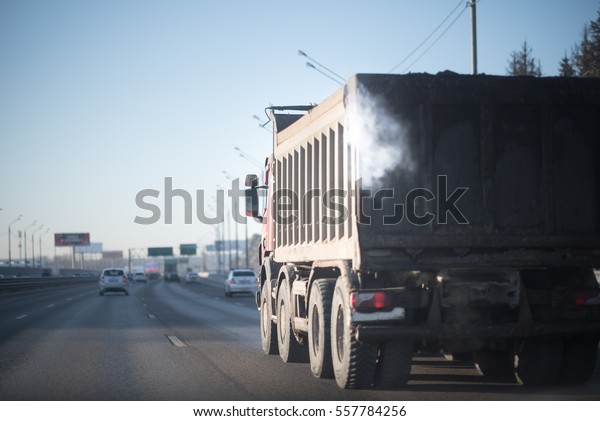 Smoked truck\
on the frosty winter road. Soft\
focus.