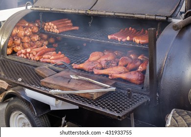 A Smoker Grill. A BBQ party with turkey legs and pork sausage. A great way to start that tailgating party - Shutterstock ID 431933755