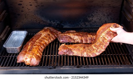 Smoker Grill With Pork Ribs Being Added By Pitmaster