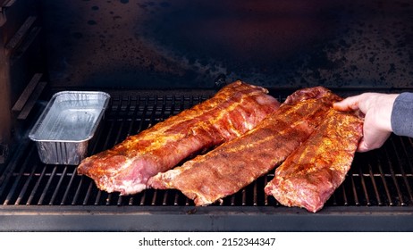 Smoker Pitmaster Adds Racks Of Ribs To A Smoker