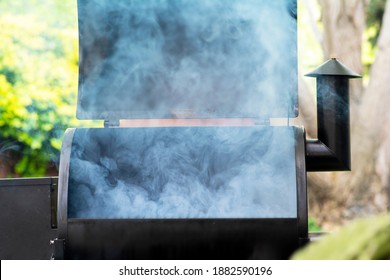 A Smoker Starting The Smoking Process, Smoke Coming From Grill.