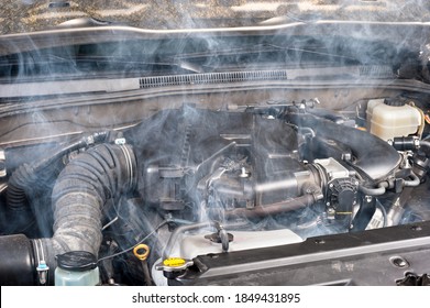 A smokey car engine shows signs of a lack of maintenance.