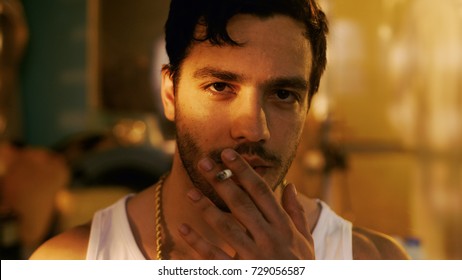 Smoking Brutal Gang Member With Gold Chain Aggressively Looks Into The Camera.