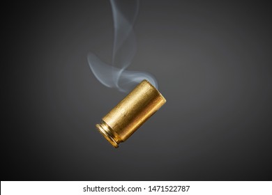 Smoking Bullet Casing Fired Out Of A Handgun Falling Down