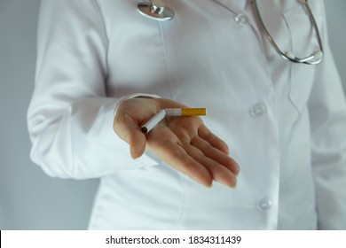 Smoking cessation concept. The doctor holds a broken cigarette in his palm close-up. - Powered by Shutterstock