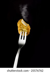 Smoking Chicken Nugget On Fork Against Black Background