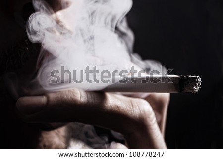 smoking cigarette in the hand of young man close up