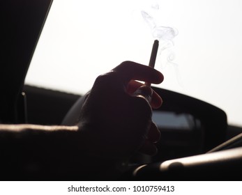 Smoking Cigarette In A Sunny Day From Inside A Car