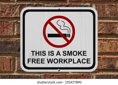 Smoking Free Workplace Sign, An Red And White Sign With Cigarette Icon And Not Symbol With Text On A Brick Wall