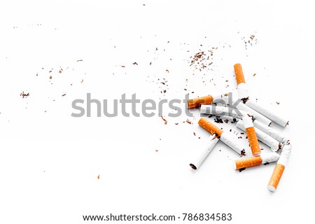 Smoking. Half-smoked cigarettes with ash on white background top view copyspace