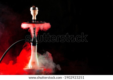 Smoking hookah on black background with color fog