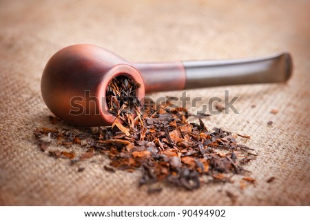Smoking pipe and tobacco on linen canvas background