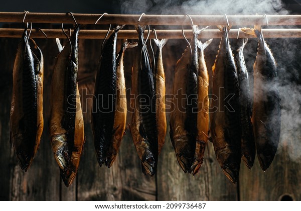 Smoking Process Fish. Fish processing smoking.\
Mackerel Fish smoked in smokehouse. Smoking Process Fish. banner,\
menu, recipe place for\
text.