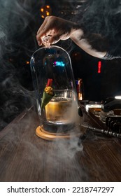 Smoky Cocktail On Wooden Table With Ice And Popcorn Garnish.