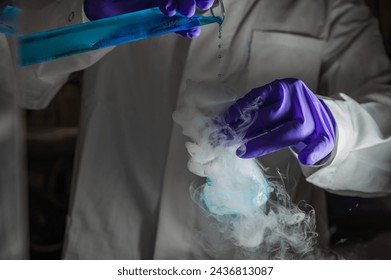 Smoky experiments with blue droplets. Scientist working on chemical reaction, generating thick smoke from a glass flask. Copyspace - Powered by Shutterstock