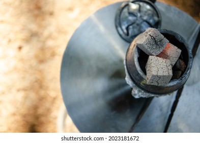 Smoldering embers in kaloud on hookah. Hookah smoking concept. Kalaud, charcoal tongs on hookah plate stands in nature. - Powered by Shutterstock - Get 15% off with code: PIKWIZARD15