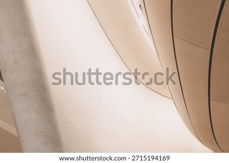 Smooth architectural forms creating an abstract pattern with concrete curves and a column, emphasizing modern design and minimalism