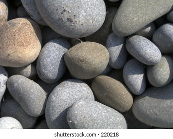 Smooth beach stones in sunlight with a touch of true grit.
