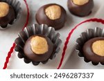 Smooth and Creamy Buckeye Chocolate and Peanut Butter Candies Chocolates on White Background with red ribbon