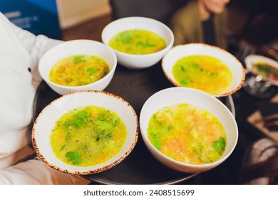 Smooth creamy soup of english smoked cheddar cheese and broccoli with toasted bread on a white tray with spoons, close-up, horizontal - Powered by Shutterstock