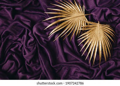 Smooth elegant purple silk or satin background and gold shiny palm leaves on it. Luxury abstract design. - Shutterstock ID 1907242786