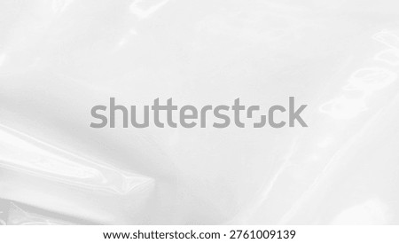 A smooth, glossy white surface with subtle reflections and folds, resembling a plastic or vinyl material. The texture suggests a soft, flexible quality.