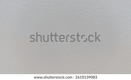 Smooth gray painted wall texture in soft neutral tones. Minimalist surface background perfect for design mockups, architectural details, or abstract compositions.