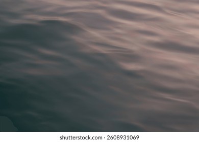 Smooth ocean waves with a soft texture. With a blend of reddish tones, the water creating a calm atmosphere