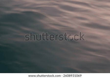 Smooth ocean waves with a soft texture. With a blend of reddish tones, the water creating a calm atmosphere