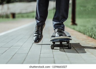 Smooth Ride. Close Up Of Male Feet Standing On Old Skateboard While Riding To Work