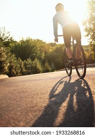 Smooth Ride. Rear View Of Male Biker Cycling On The Road In Park On A Sunny Day