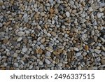 Smooth round pebbles texture background. Pebble sea beach close-up, dark wet pebble and gray dry pebble. natural gravel, texture from gravel. Gravel texture. Pebble stone background. Granite gravel