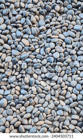 Smooth round pebbles texture background. Pebble sea beach close-up, light wet pebble and gray dry pebble. High quality photo
