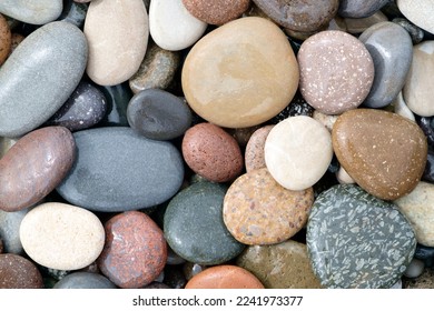 Smooth round wet pebbles texture background. Pebble sea beach close-up