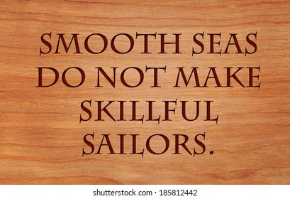 Smooth seas do not make skillful sailors. - African Proverb on wooden red oak background